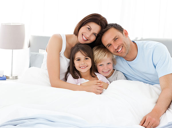 happy family in bed posting for picture